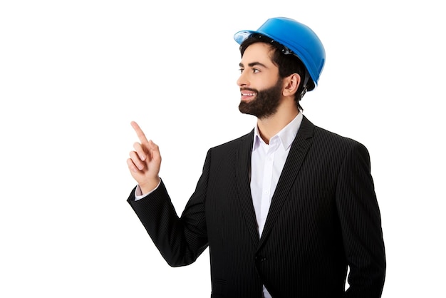 Businessman in blue hardhat pointing against white background