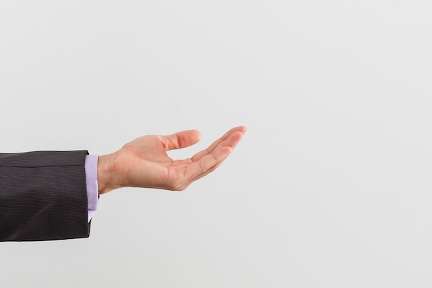 Photo businessman in blue suit presenting empty palm - it can be used to advertise product on his hands.