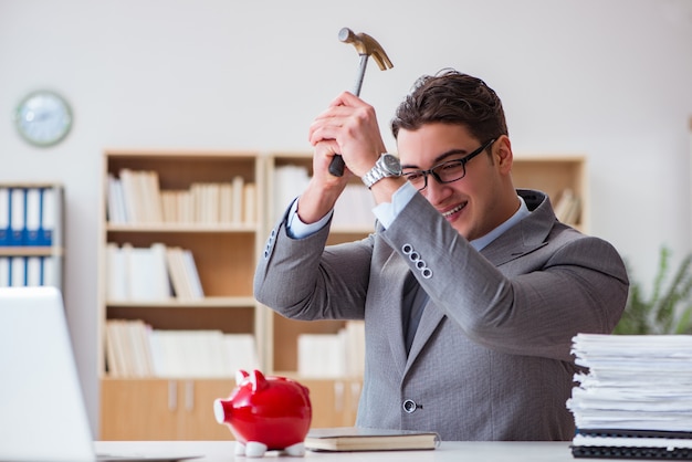 Photo businessman breaking piggybank in the office