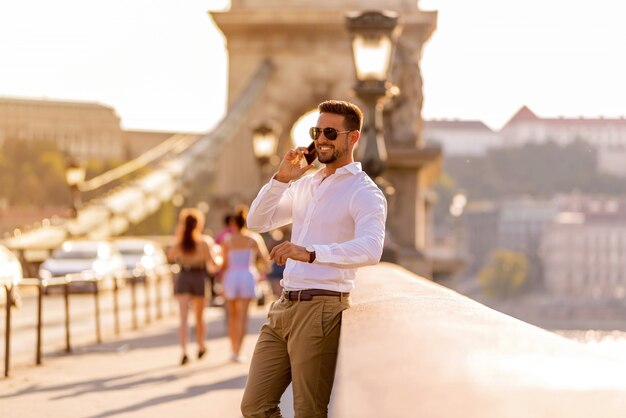 A businessman on a bridge and talking on his phone