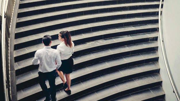 L'uomo d'affari e la donna di affari salgono le scale concetto di successo