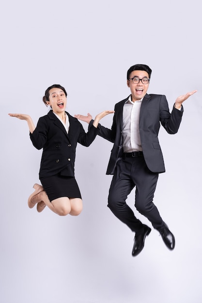 Businessman and business woman jumping on white background