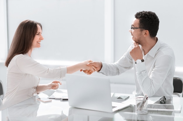 Businessman and business woman shaking hands in office