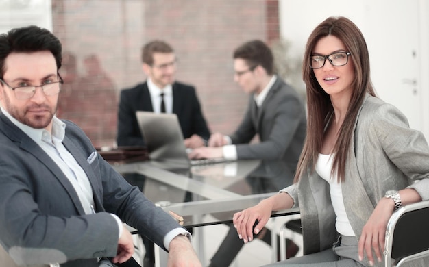 Businessman and business woman sitting at the desk