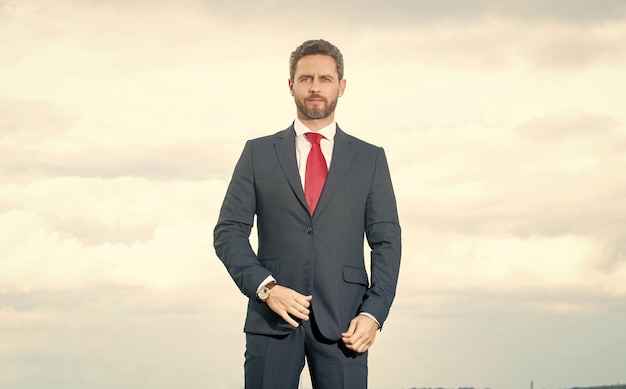 Businessman in businesslike suit on sky background