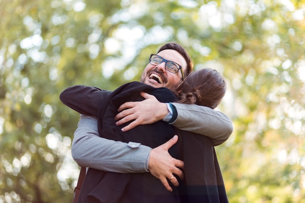 Businessman and businesswoman hugging outdoor