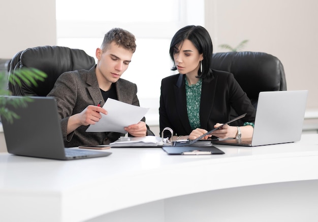 Businessman and businesswoman meeting in modern office working on laptop business meeting