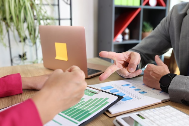 Businessman and businesswoman playing game rock paper scissors when discussing details of agreement