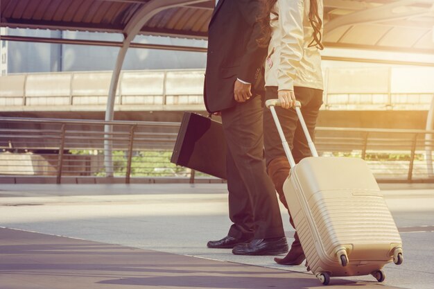 Businessman and businesswoman traveler withluggage at city background