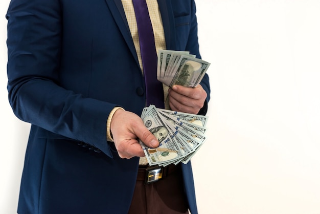 Businessman buying or renting a product or service, giving dollars, isolated on white. The male hand offers a bribe.