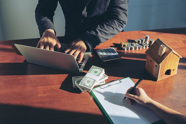 Foto uomo d'affari che compra e che vende case e concetto di prezzi del bene immobile. affare che firma una casa di vendita del contratto