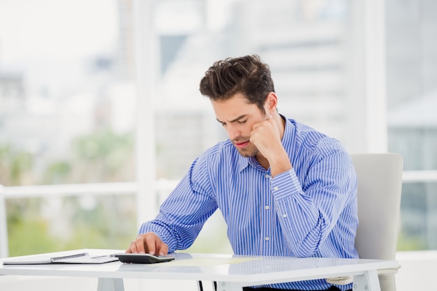 Businessman calculating accounts on a calculator