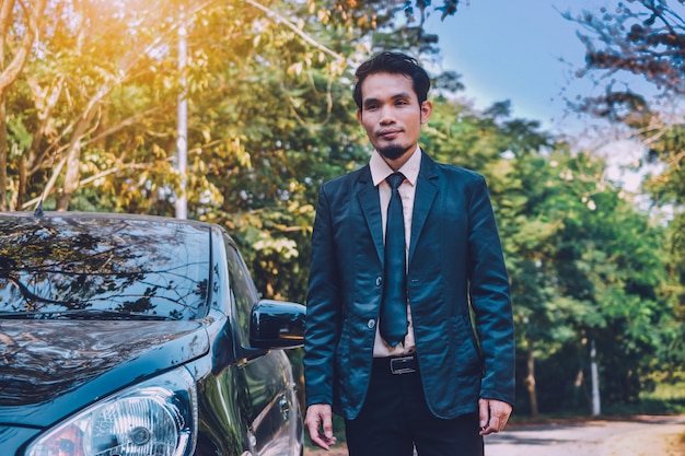 Businessman and car parked on street, insurance marketing concept