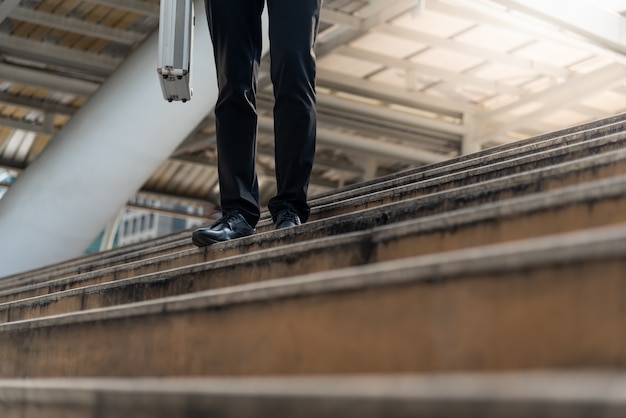 Businessman carrying a briefcase walk up stair.