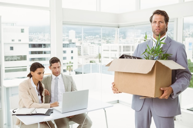 Businessman carrying his belongings in box