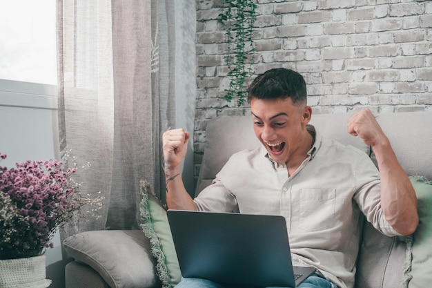 Businessman celebrating market business going well making money\
trader enjoying profits working from home with laptop happy fan boy\
winning a bet of sportxa