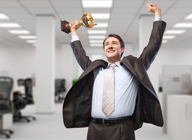 Businessman celebrating with trophy in hand