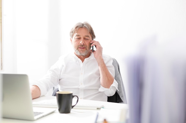 Businessman on cell phone at desk