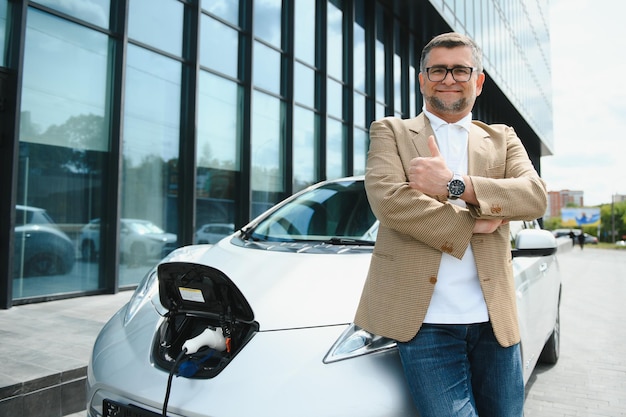 A businessman charges an electric car