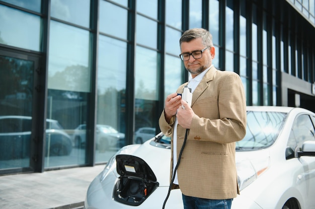 A businessman charges an electric car