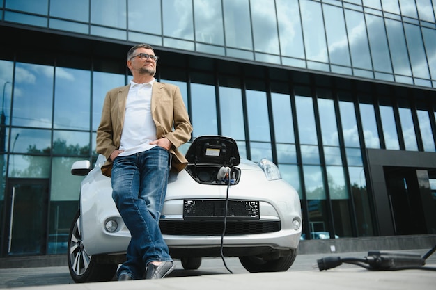 A businessman charges an electric car