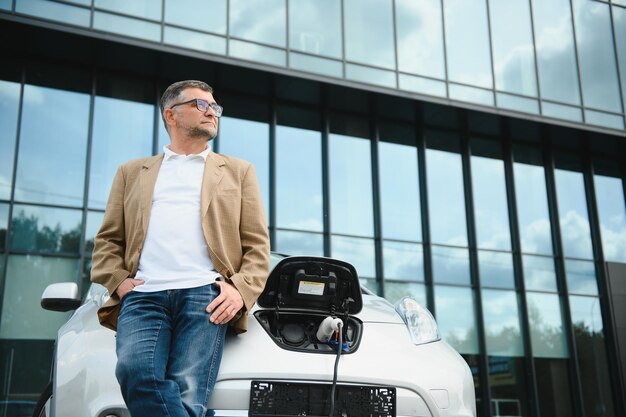 A businessman charges an electric car