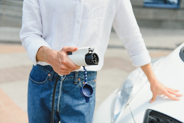 電気自動車を充電するビジネスマン