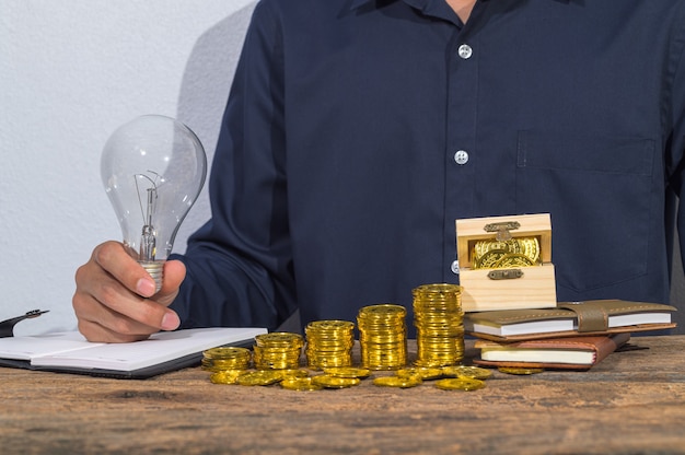 Businessman checks accounts documents and money saving ideas on the table.