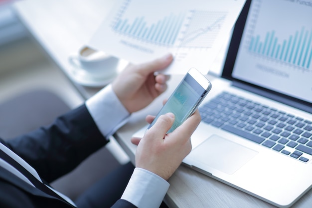 businessman checks the financial data using a smartphone.