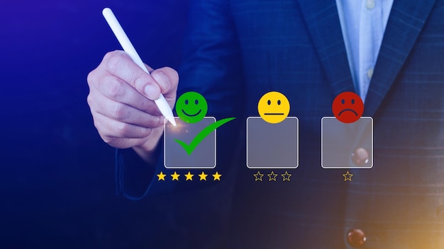 Uomo d'affari che sceglie la valutazione del feedback dell'icona del viso sorridente felice e la valutazione positiva della salute mentale del sondaggio sulla soddisfazione dell'esperienza della recensione del cliente