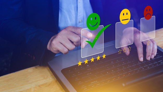 Uomo d'affari che sceglie la valutazione del feedback dell'icona del viso sorridente felice e la valutazione positiva della salute mentale del sondaggio sulla soddisfazione dell'esperienza della recensione del cliente