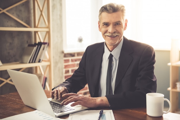 Businessman in classic clothes is looking at camera.