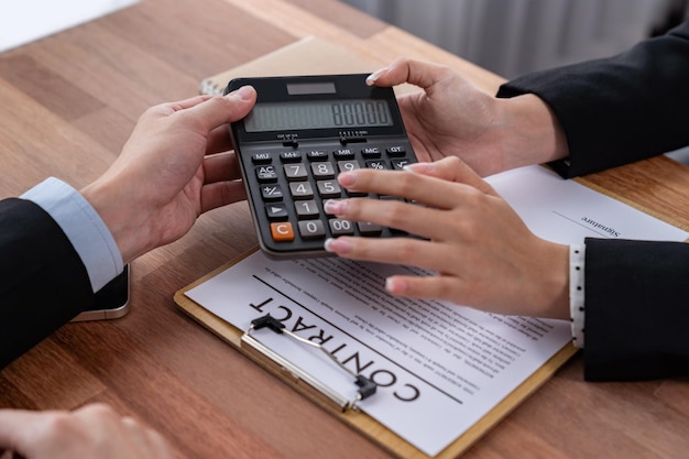 Businessman and client discuss the paperwork with calculator Jubilant