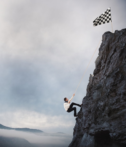 Businessman climbs a mountain to get to the flag. Achievement business goal and Difficult career concept