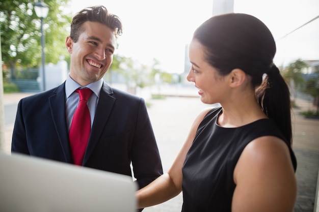 Businessman and colleague discussing over laptop