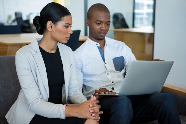 Businessman and a colleague discussing over laptop