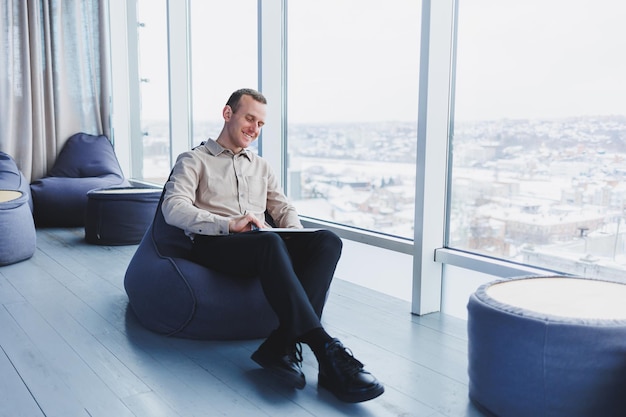 A businessman communicates with his clients by phone while
sitting in a modern office workspace focused businessman sits alone
in a modern workspace