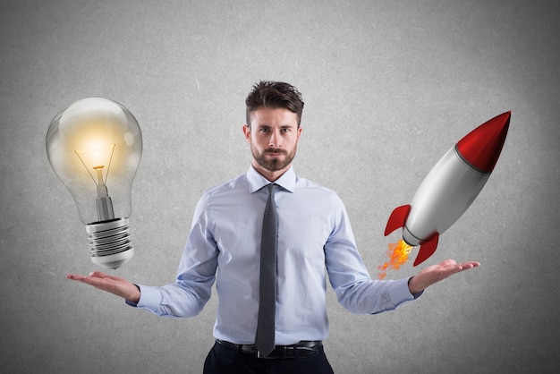 ビジネスマンは電球をロケットと比較します。コンセプトとアイデアとスタートアップ
