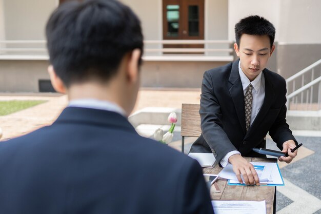 사진 사업가 개념은 건물 내부에 있는 계산기와 노트북으로 회계 업무를 하는 남성 사무원입니다.