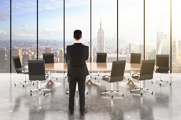 Businessman in a conference room with wooden table and chairs