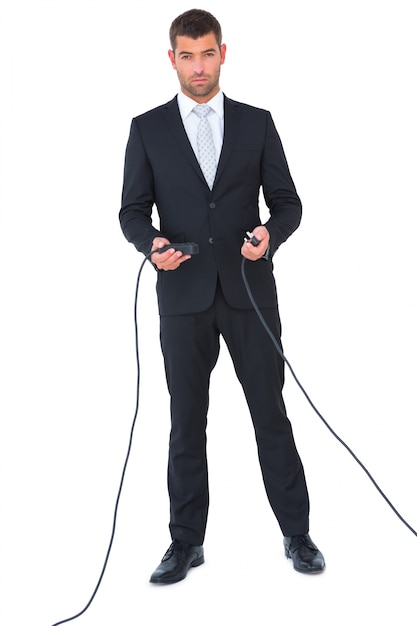 Businessman connecting cables together