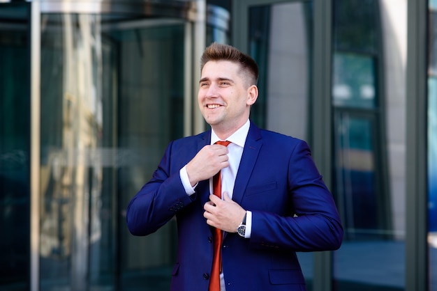 Businessman corrects tie and smiling.