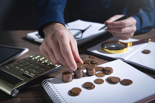 Businessman counting coins on the desk.