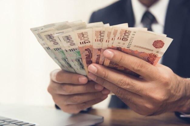 Photo businessman counting money, russian ruble currency, at his working desk 