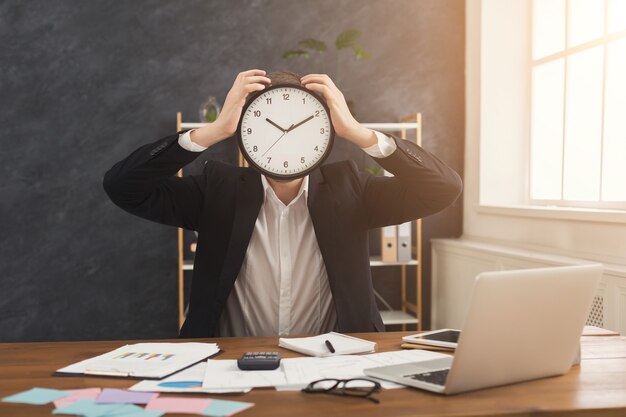 Photo businessman covering face with clock. portrait of man with watches at office. time management and time is the most presious resource concept, copy space