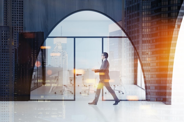 Businessman in a dark wooden office interior with a white floor, arched doorways and a long meeting room table with white chairs standing near it. 3d rendering mock up toned image double exposure