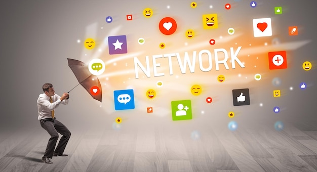 businessman defending with umbrella from social media
