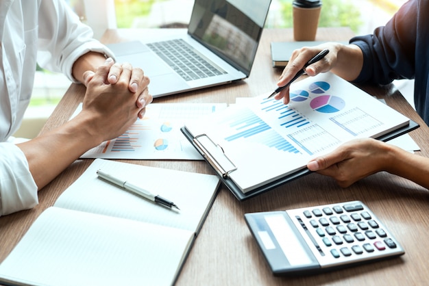 Businessman discuss explaining new trends information on a document with colleague co-worker or partner together in a modern business office.