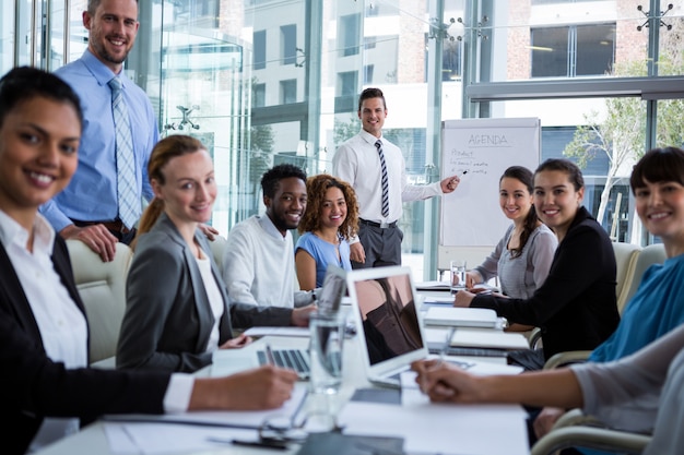 Businessman discussing on white board with coworkers