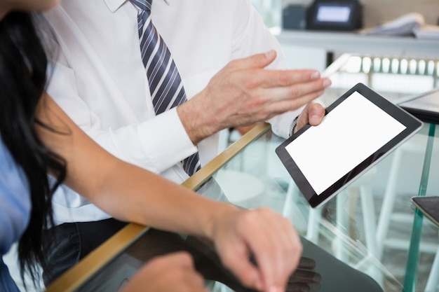 Uomo d'affari che discute con il collega sopra la compressa digitale